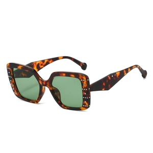 Fashionable square tortoise shell sunglasses with deep green lenses and rivet accents