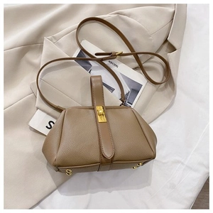 Close-up of brown litchi pattern leather bag showing gold hardware and metal base studs