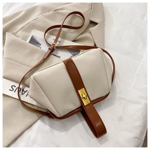 Detail of vintage cream pebbled leather shell bag with gold twist lock and brown strap