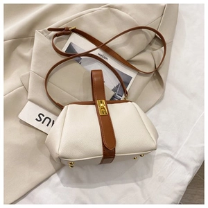 Detail of elegant white shell bag with brown leather strap and golden turn-lock