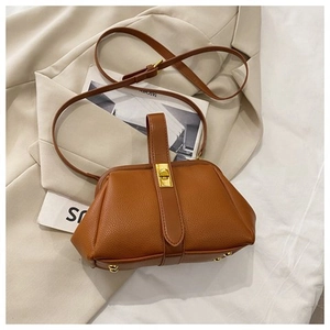 Close-up of brown pebbled leather shell bag with gold clasp and adjustable strap
