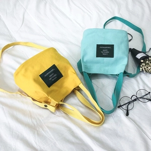 Minimalist canvas bucket bags in bright yellow and mint green with adjustable straps