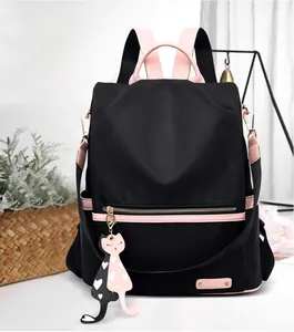 Détail du sac à dos en tissu Oxford noir et rose avec pendentif chat et logo métallique