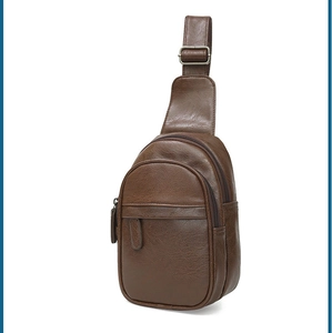 Close-up of dark brown PU leather chest bag with zipper compartments and adjustable strap