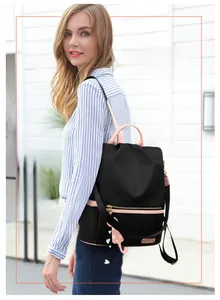 Vue détaillée d'un sac à dos noir en tissu Oxford avec accents roses et charm de chat