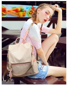 Détail du sac à dos en oxford avec bretelles en cuir rose et breloque chat