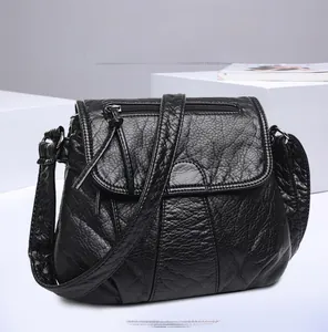 Macro shot of black washed PU leather texture with vertical pleats on a crossbody bag