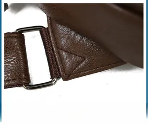 Close-up of durable reinforced triangular stitching and silver metal D-ring on brown leather bag