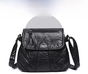 Detail of black washed PU leather crossbody bag with tassel and pleated texture