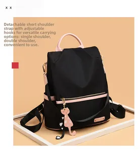 Détail d'un sac à dos en tissu Oxford imperméable avec bordure rose et pendentif chat mignon