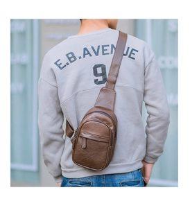 Detailed view of the brown leather chest bag with a textured finish and adjustable strap