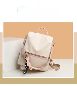 Détail d'un sac à dos en tissu Oxford imperméable avec poignée rose et porte-clé chat