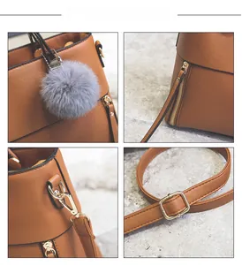Close-up of caramel brown tote bag with grey plush ball charm and gold hardware details