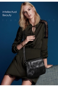 Detail of black textured soft PU leather crossbody bag with quilted finish and flap design