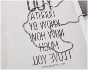 Detailed macro view of a polished silver snake chain on a decorative white display card