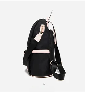 Vue détaillée du sac à dos en nylon noir imperméable avec garniture en cuir rose et or