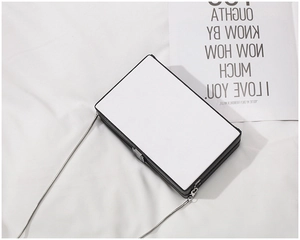 Detail of creative acrylic box bag with metal lock and elegant silver chain strap