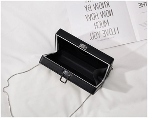 Detail view of the black acrylic box bag interior with metal chain and inner pocket