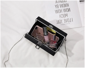 Interior view of black acrylic clutch box showing capacity for phone and cosmetics