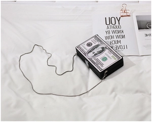 Detail shot of rectangular acrylic box clutch bag with artistic 100 dollar bill print