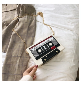 Detailed close-up of retro cassette tape shaped white shoulder bag with gold chain