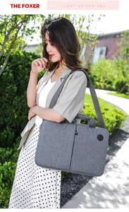 Close-up of gray waterproof fabric texture and front zipper pocket on 15 inch laptop bag