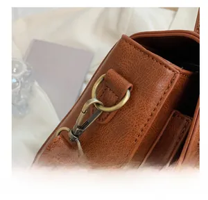 Close-up of bronze vintage clasp and textured brown leather on retro handbag