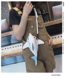 Detail view of the quirky white shark shaped leather crossbody bag with blue fins
