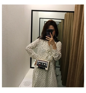 Mirror selfie showing a creative retro cassette tape cross-body bag with music patterns
