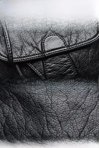 Close-up of black litchi grain PU leather with fine stitching details on the handbag