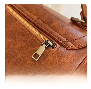 Macro view of smooth metal zipper and textured brown PU leather on a vintage bag