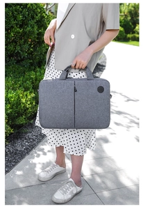 Gray business laptop bag in textured water-resistant fabric with padded handle and logo
