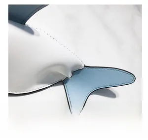 Detail shot of blue and white shark-shaped bag with contrast stitching and PU leather texture