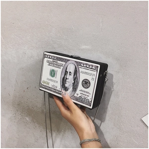 Detailed close-up of acrylic box clutch with dollar bill print and silver chain strap