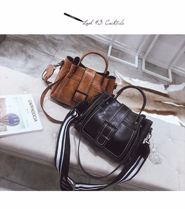 Brown and black matte leather handbags with chic striped wide straps and large metal buckles