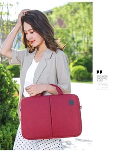 Burgundy business laptop bag with fine fabric texture held by a professional model