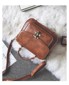 Top view of brown vintage PU leather handbag with bronze buckle and detachable strap