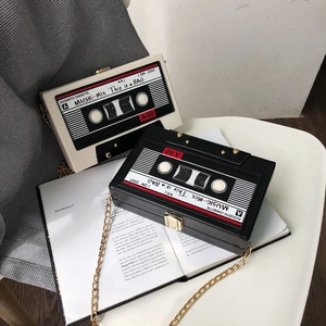 Detail of vintage cassette clutch bags with gold chains on a stylish magazine