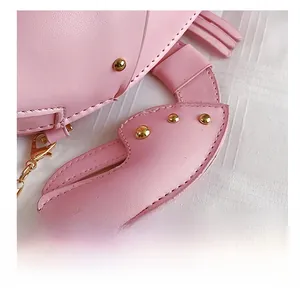 Detail showing neat stitching and golden rivets on pink crab-shaped leather crossbody bag