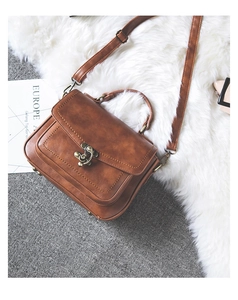 Close-up of deep caramel brown PU leather handbag with vintage bronze clasp and strap