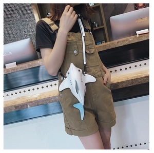 Detail of the creative shark-shaped crossbody bag featuring white leather and blue fin
