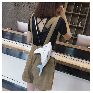 Detail of white and blue shark-shaped crossbody bag with adjustable strap and back zipper