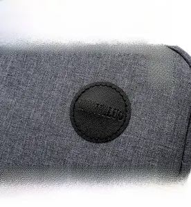 Detailed macro view of the grey fabric texture and black circular embossed brand logo