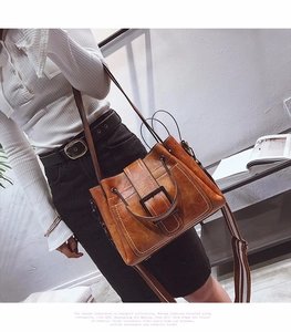 Close-up of vintage brown matte leather crossbody bag with a wide striped woven strap