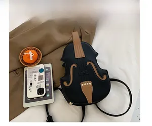 Detail of violin-shaped crossbody bag featuring premium stitching and gold studs