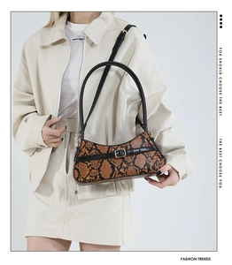 Close-up of retro snakeskin pattern leather on brown crescent underarm baguette bag