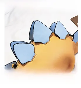 Detailed view of yellow PU leather bag with blue dinosaur fins and neat stitching