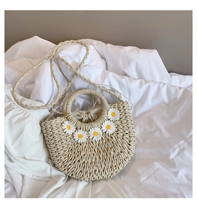 Dettaglio della borsa in paglia intrecciata con decorazioni margherite e coulisse