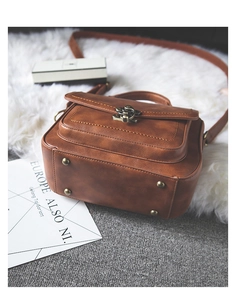 Detail shot of the vintage brown PU leather bag base with four metal protective rivets