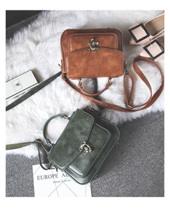 Close-up of vintage PU leather bags with bronze carved locks in brown and green
